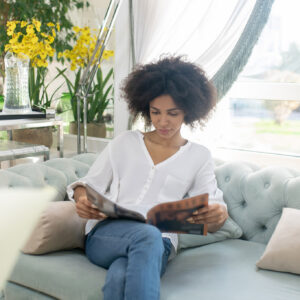Smiling young woman reading magazine