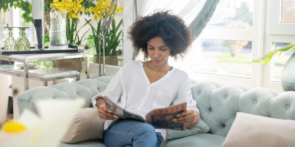 Smiling young woman reading magazine